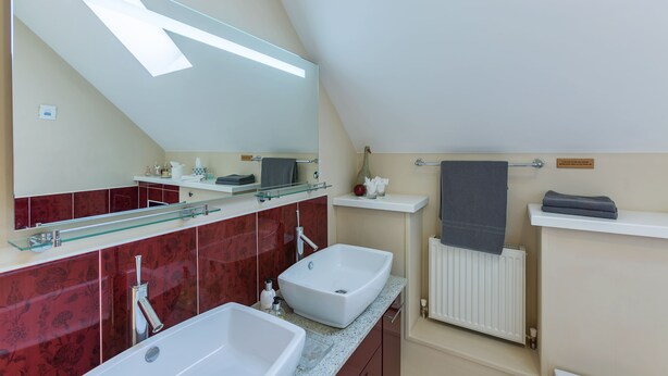 A modern bathroom with two sinks, a large mirror, and a glass shelf. - Dun Ard (Dungarvan)