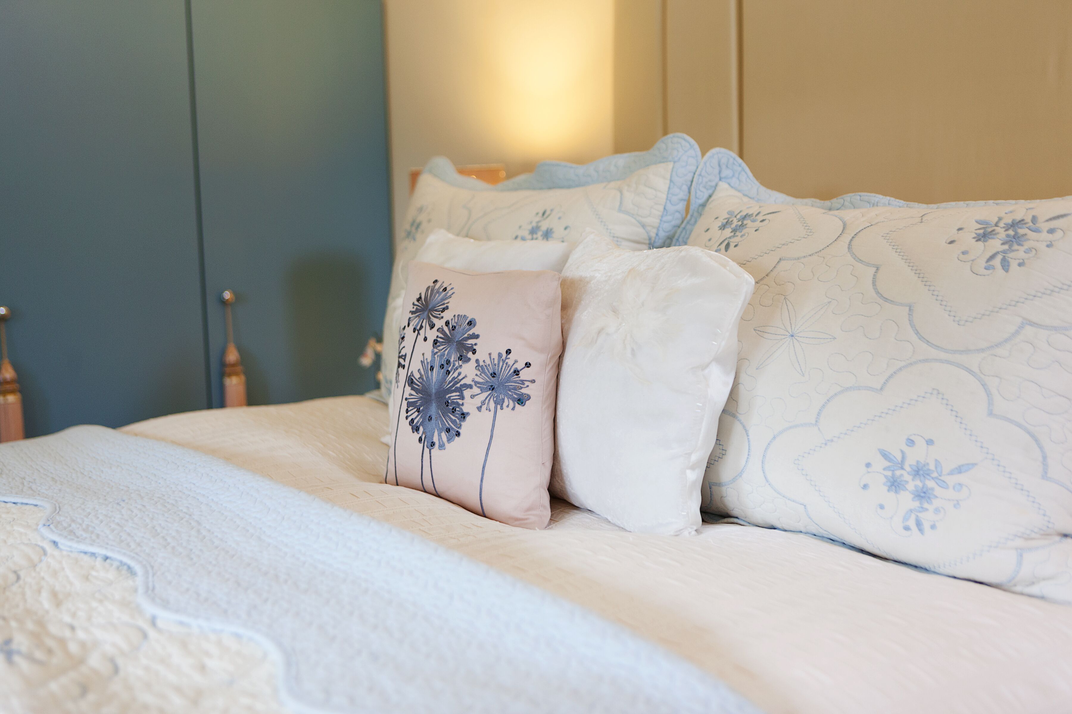 A neatly made bed with a patterned bedspread and decorative pillows.