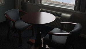 A room with a view of the ocean, a round table, and two chairs. - The Cutty Sark Motel (York Beach)