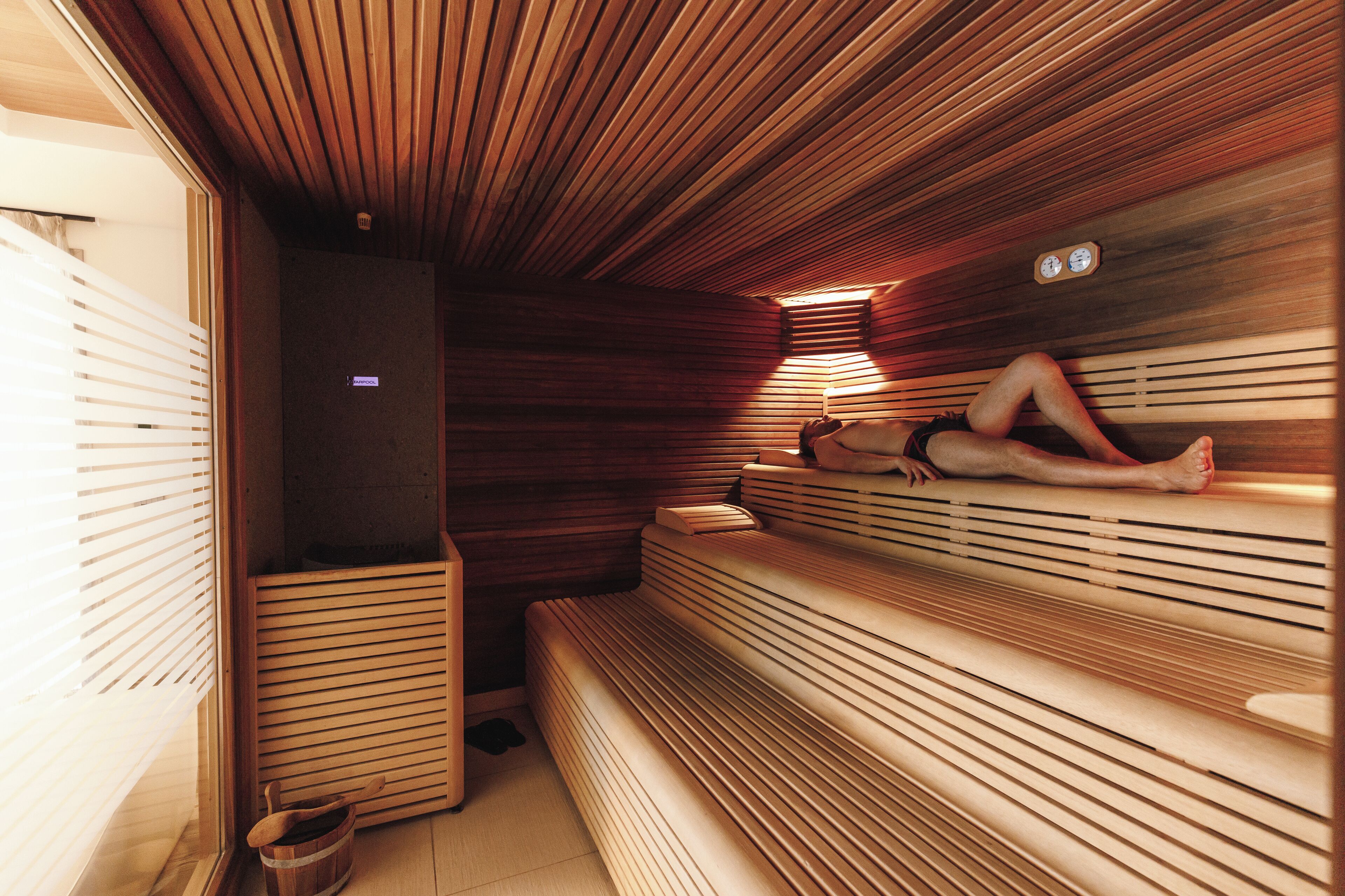 A sauna with wooden benches and a sloped ceiling.