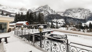 Eine verschneite Berglandschaft mit einem Gebäude und einem Zaun im Vordergrund.