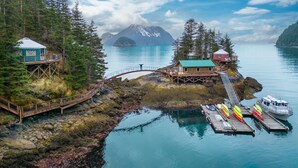 A lakeside cabin with a dock, surrounded by forest and mountains. - Orca Island Cabins (Seward)