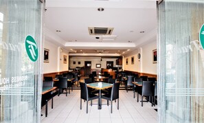 A spacious restaurant with high ceilings, recessed lighting, and a central serving area.