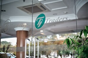 A glass door with the logo "Traders" and a brass elevator.