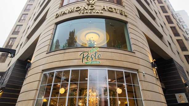 Exterior del Hotel Diamond, con un amplio ventanal que muestra el interior.