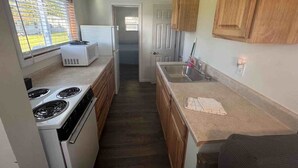 Una cucina con forno, microonde e lavandino.