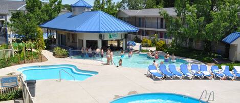 A swimming pool area with lounge chairs and a covered seating area.
