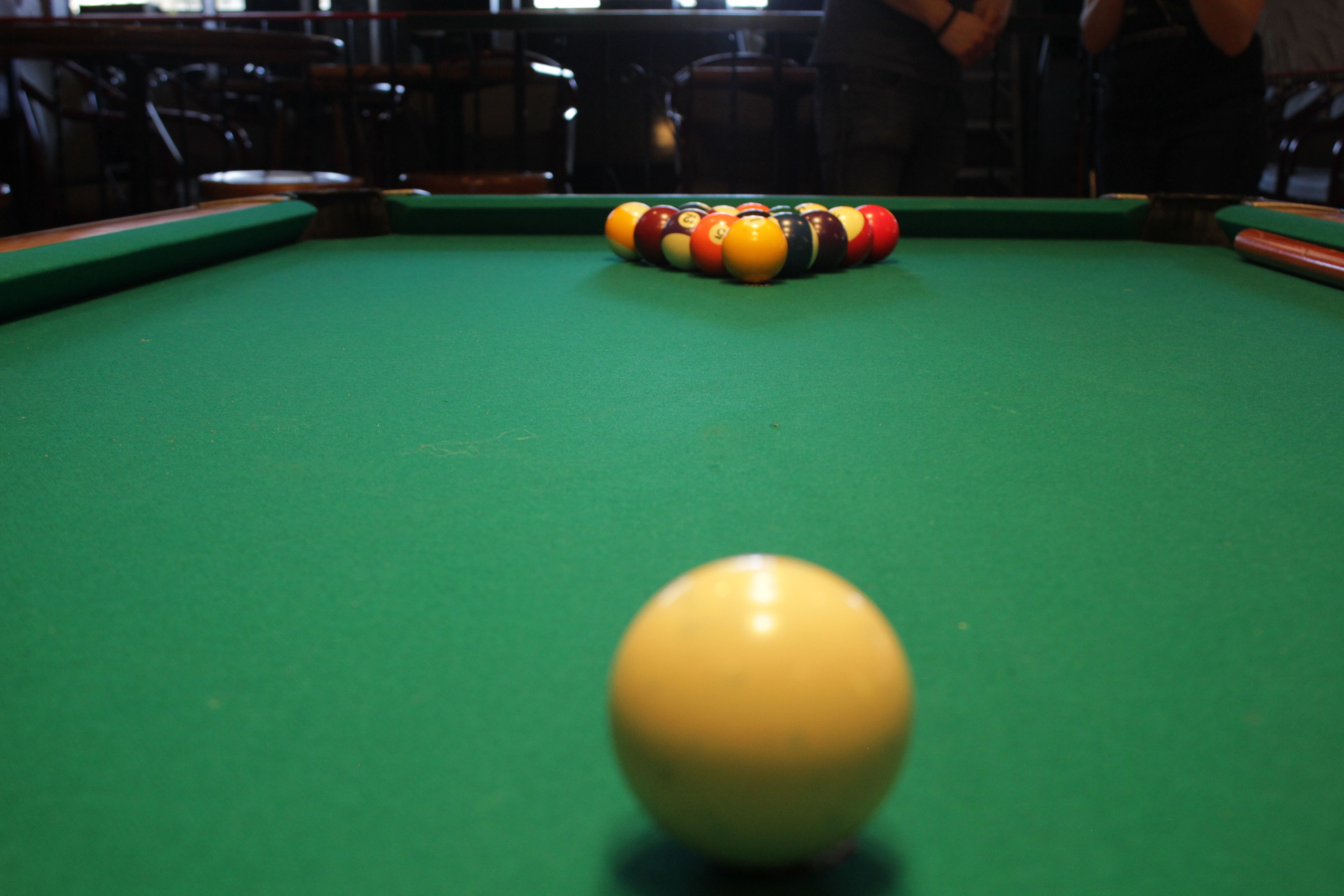 Una mesa de billar con una bola amarilla y una disposición a rayas.