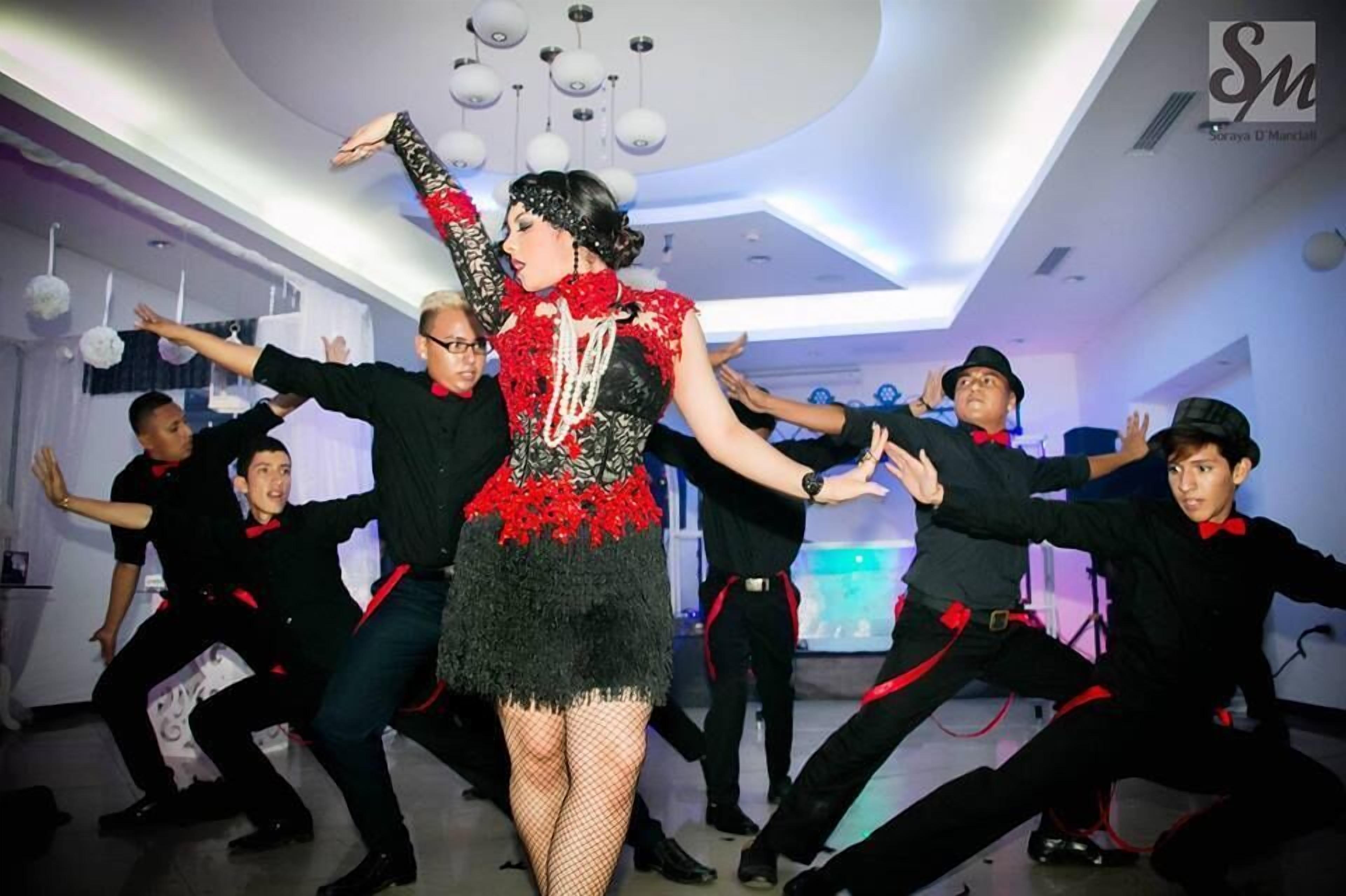A dance performance in a modern room with a high ceiling and contemporary lighting fixtures.