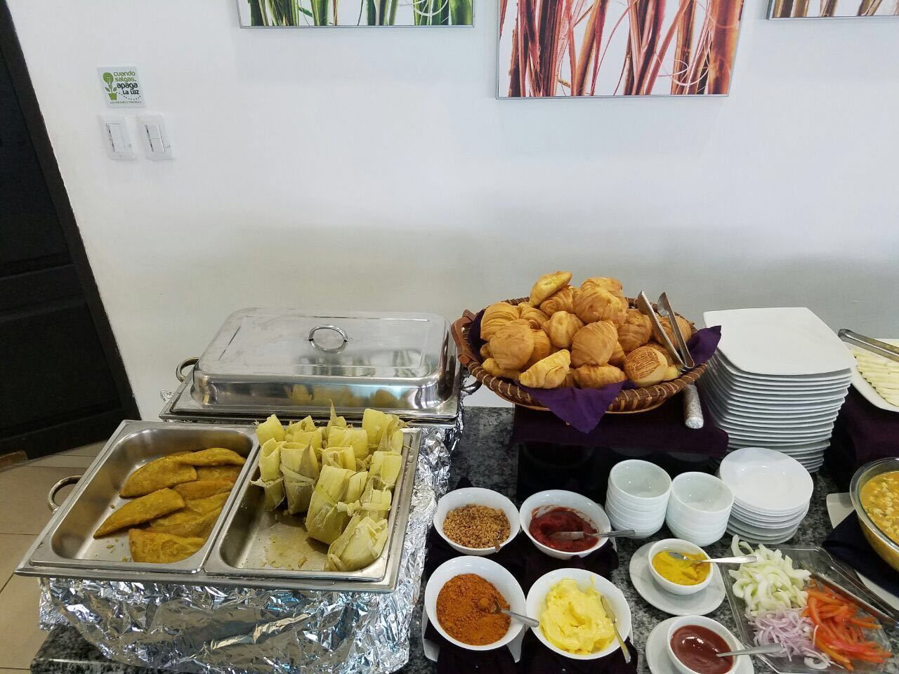 A buffet table with various food items and condiments.