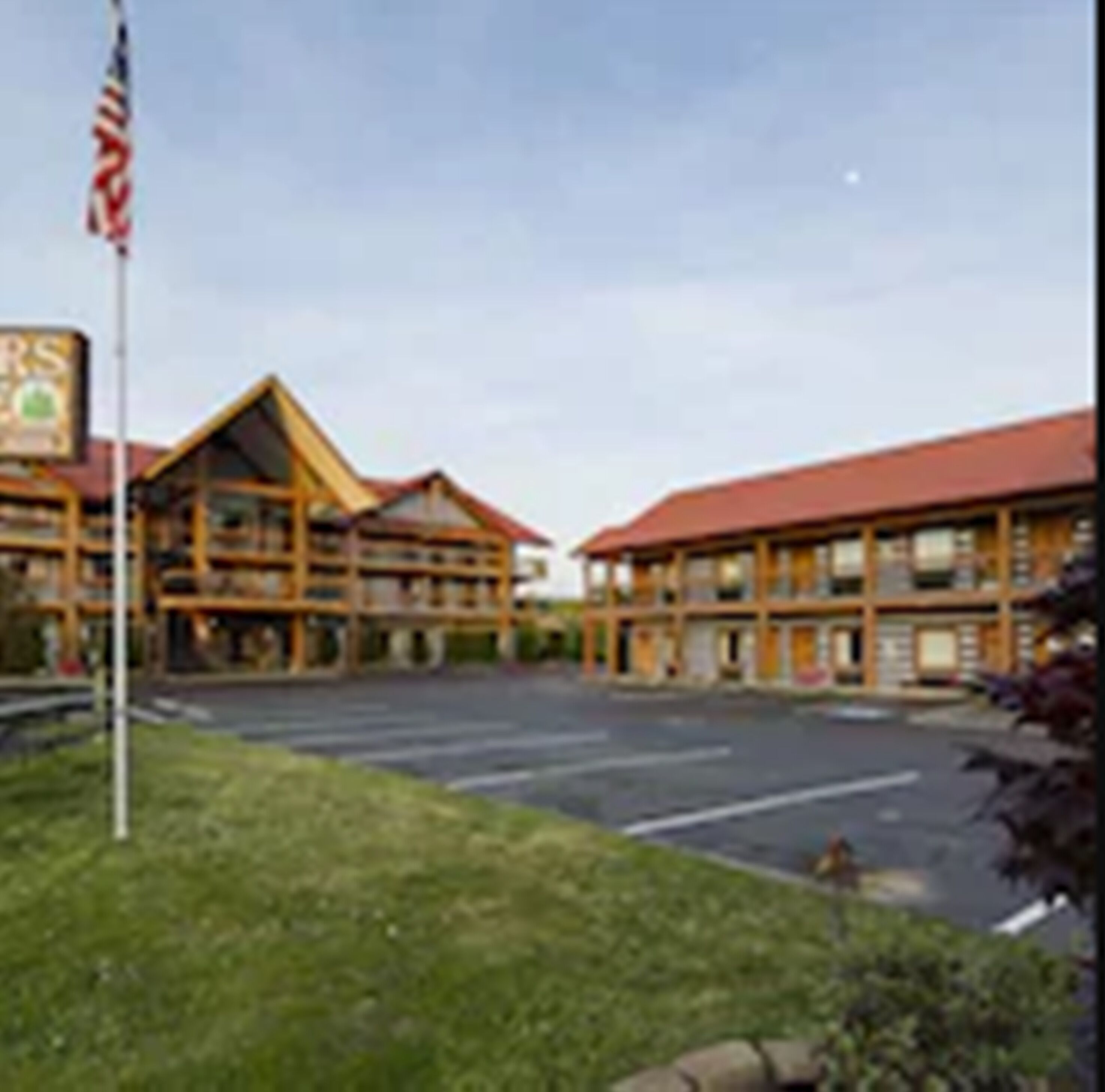 A lodge with a red roof and multiple wooden structures.