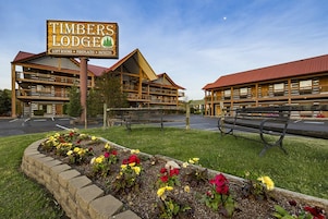 A lodge with a prominent sign, multiple buildings, and a landscaped flower bed.