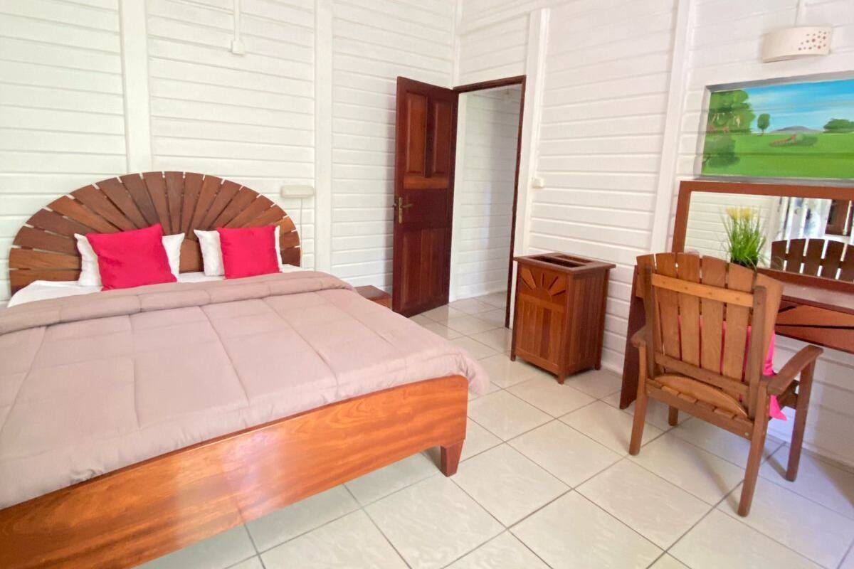 A bedroom with a wooden bed, a desk, and a chair.