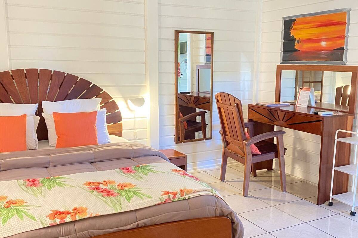 A bedroom with a bed, a desk, and a chair.