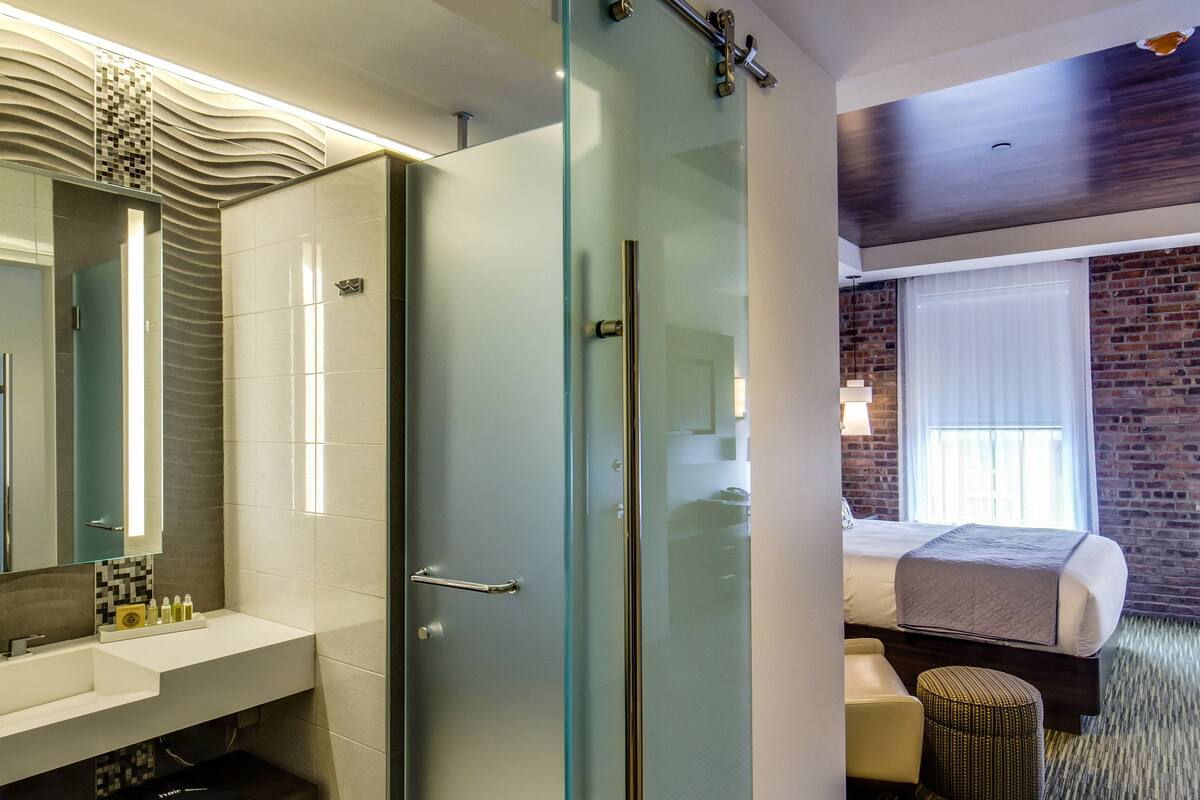 A modern bathroom with a glass shower enclosure, a vanity with a mirror, and a sink.