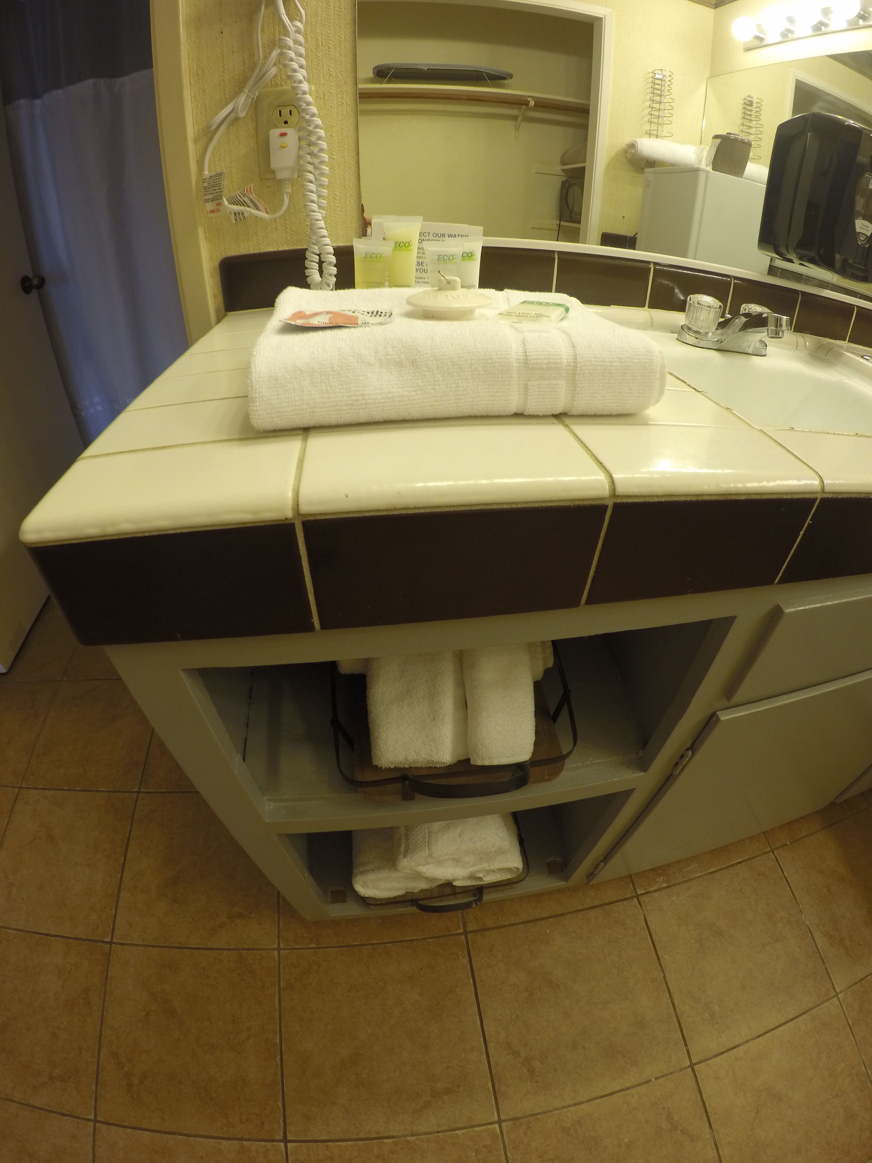 Een badkamer met een wit wastafel, een spiegel en een handdoekhouder.