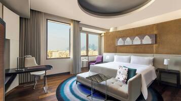 Un hotel moderno con una cama grande, un escritorio, una silla y vistas a la ciudad.