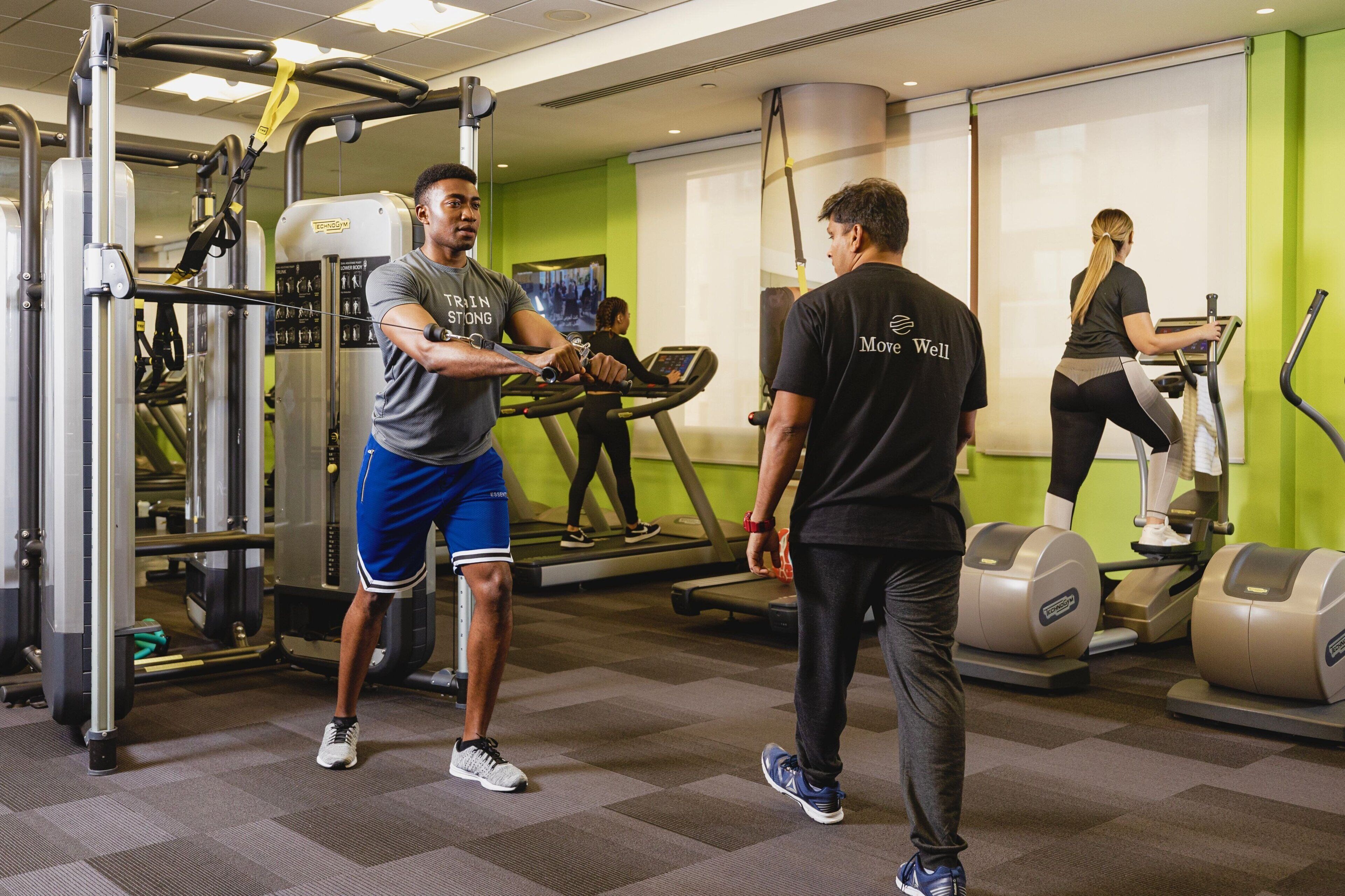 A gym with exercise equipment, a treadmill, and a mirrored wall.