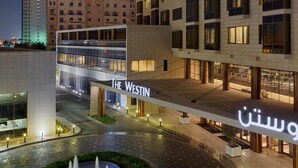 Un hotel moderno con una entrada destacada y un cartel que dice 'The Westin'.