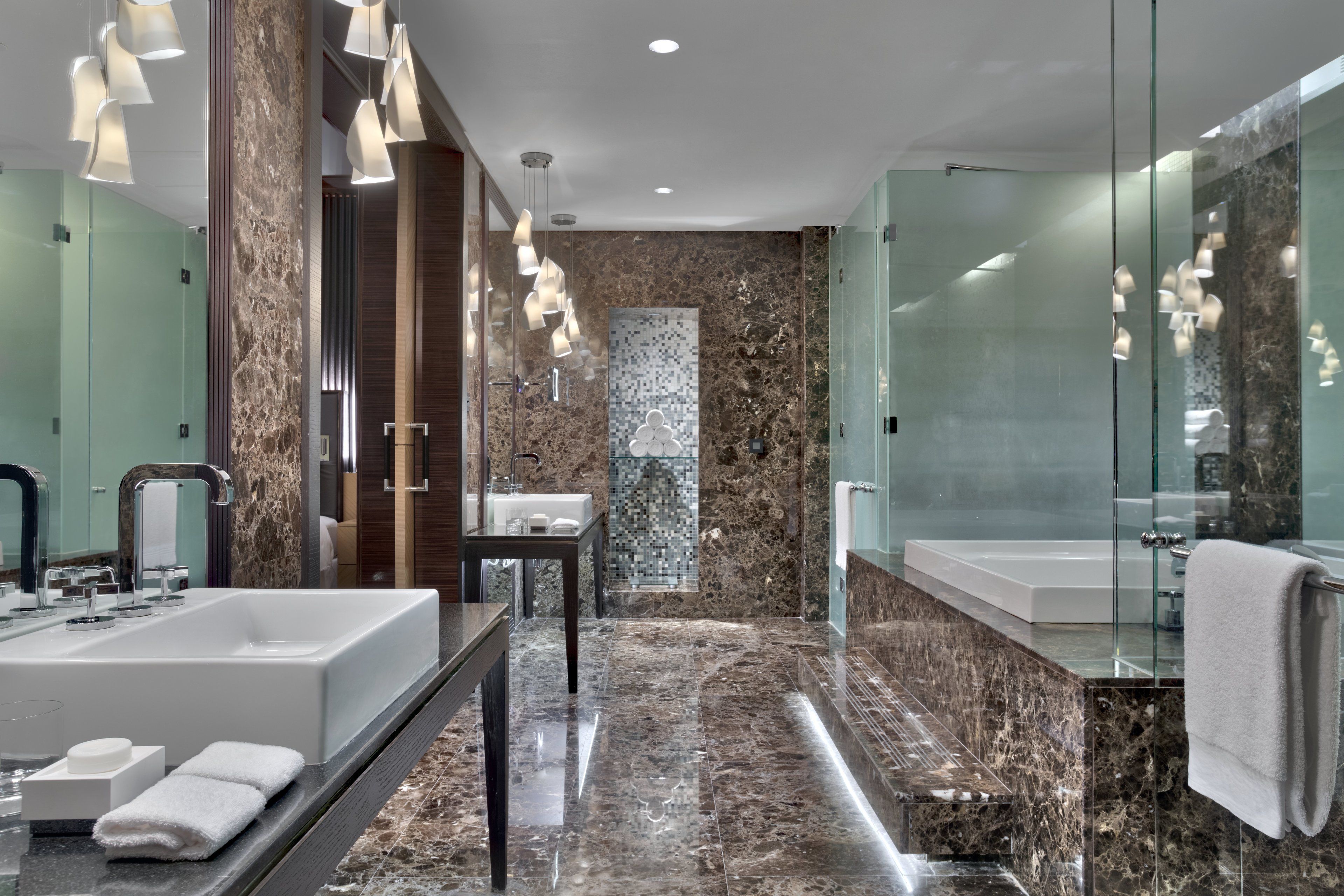 A modern bathroom with a large sink, a mirror, and a glass shower enclosure.