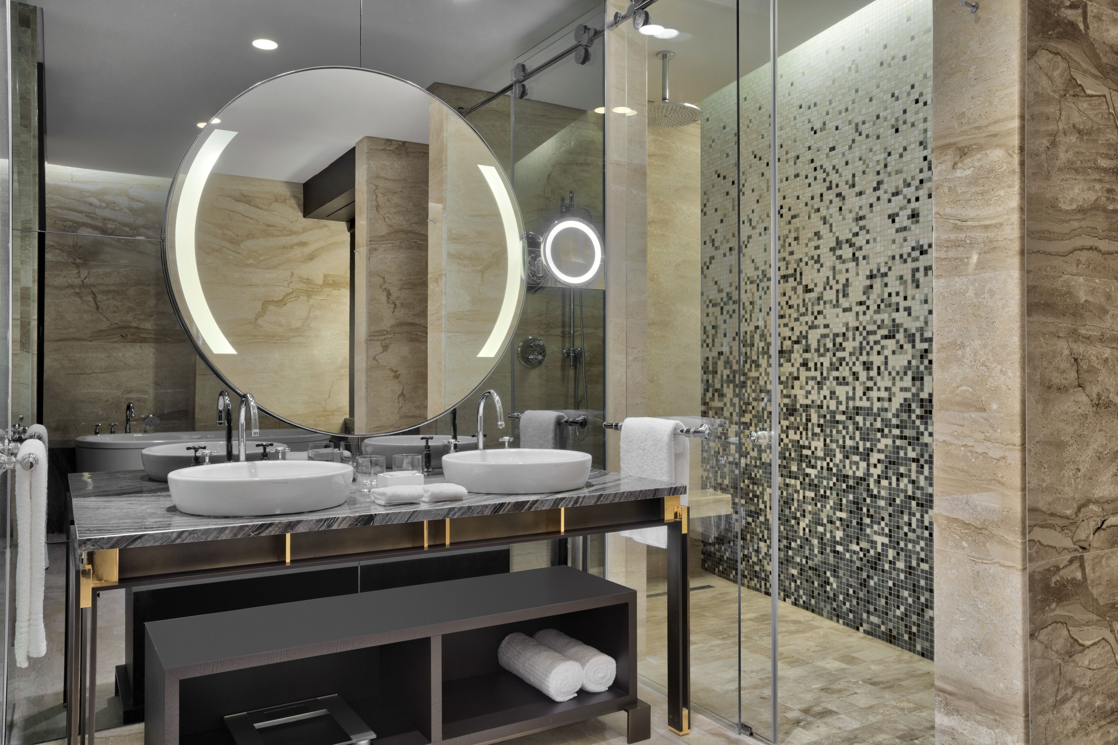 A modern bathroom with two sinks, a large mirror, and a glass shower enclosure.