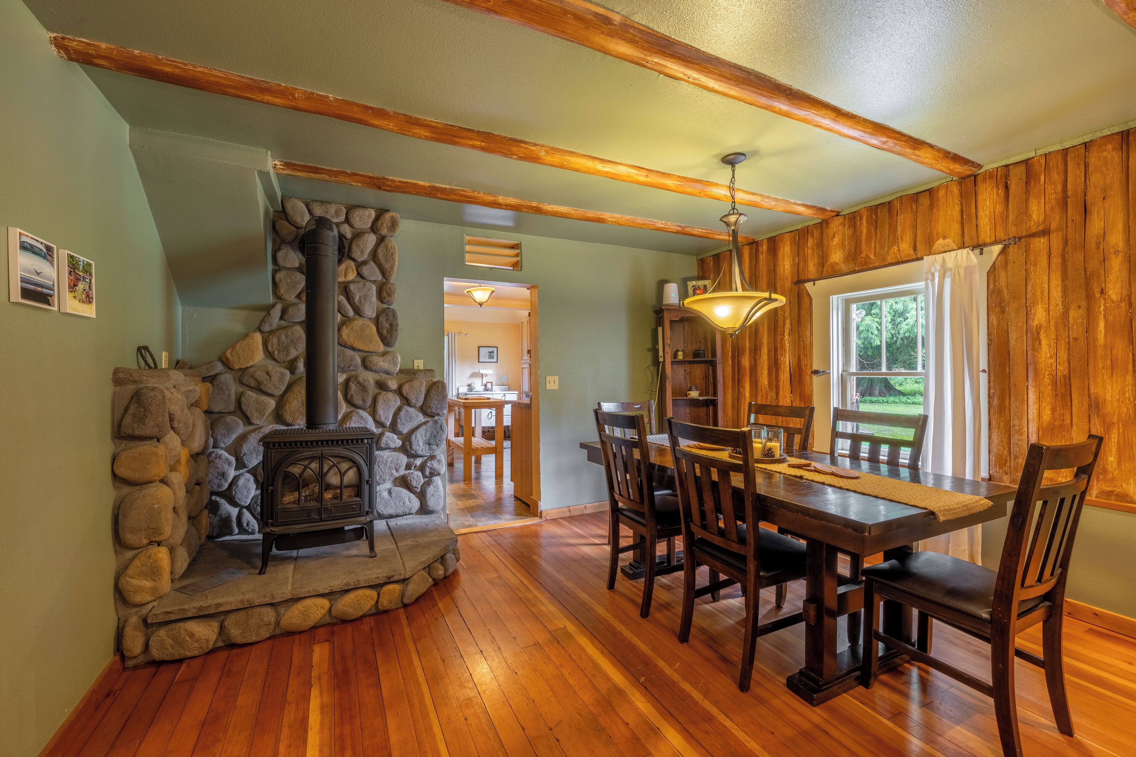 Un comedor acogedor con chimenea de piedra, mesa y sillas de madera.