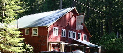 A red building with a metal roof, labeled as a restaurant, lodging, and gift shop.