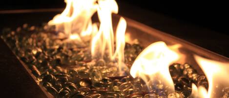 A close-up of a fire burning through glass pebbles.