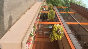 A residential building with a balcony featuring a concrete ledge and wooden railing.