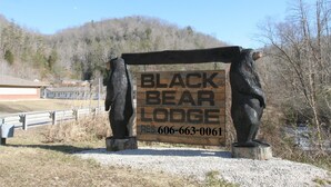 A wooden signboard for Black Bear Lodge with a contact number. - Black Bear Lodge Motel (Slade)