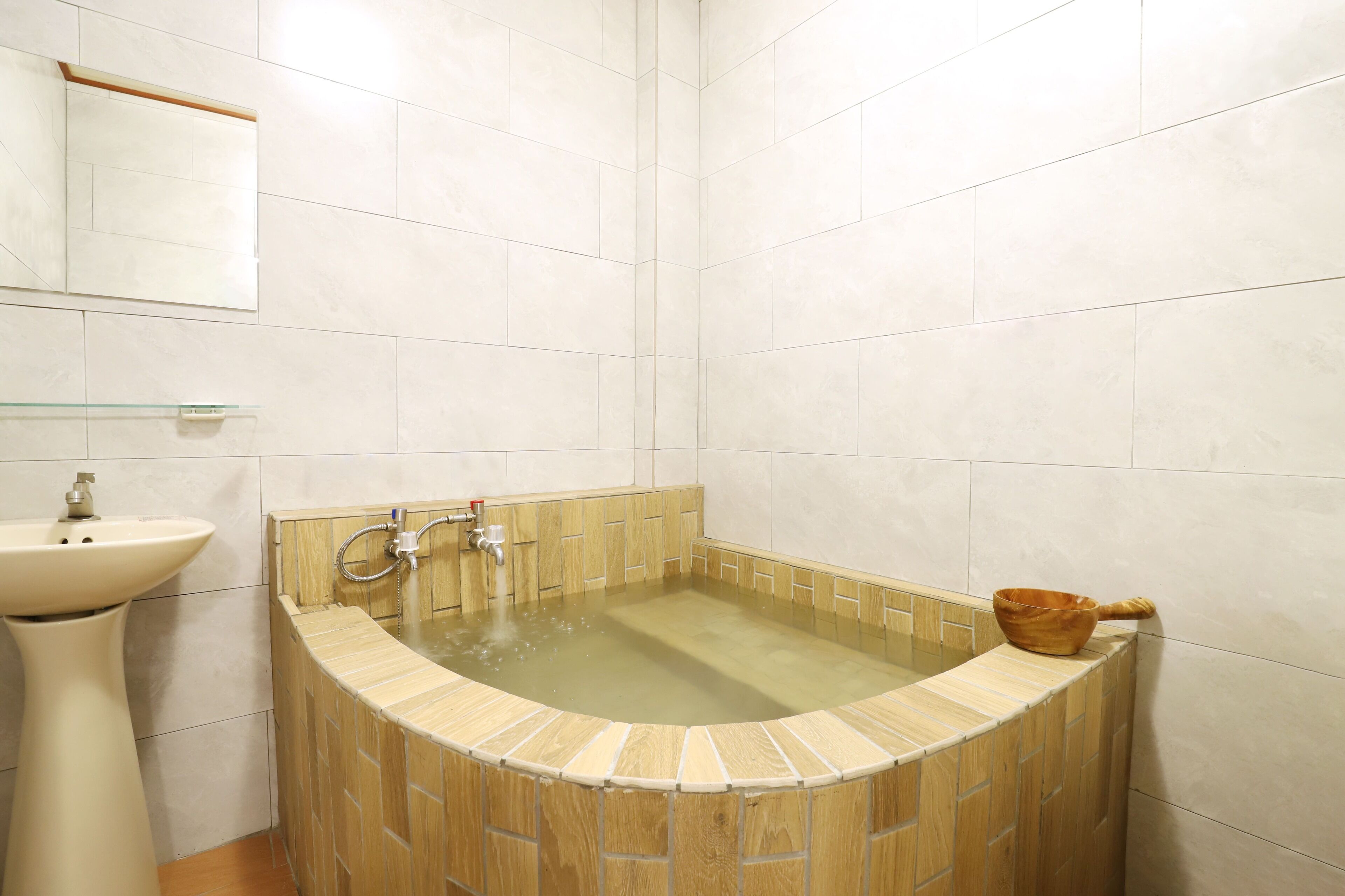 A bathroom with a freestanding bathtub, a sink, and a mirror.