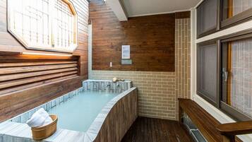 A spa area with a wooden bench, a hot tub, and a tiled floor.