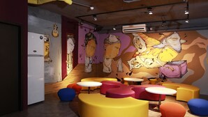 Un interno moderno con sedute colorate e un murale.