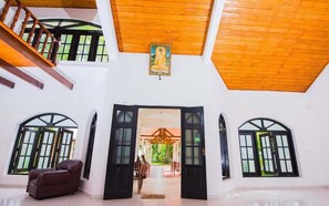 A spacious room with a high ceiling, a staircase, and a large open doorway leading to an outdoor area. - Latheena Resort (Weligama)