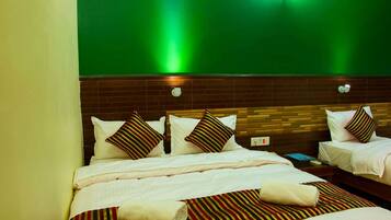 Una habitación de hotel con dos camas, una pared de ladrillo y una pared verde.