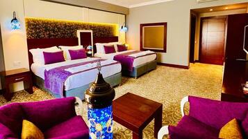 Una habitación de hotel con dos camas, un jarrón grande y muebles morados.