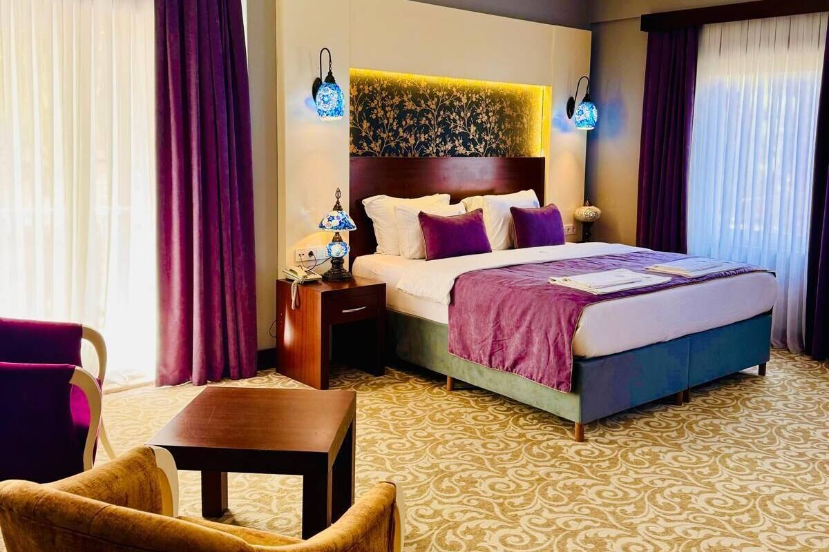 Ein Hotelzimmer mit Bett, Nachttisch, Stuhl und Tisch.