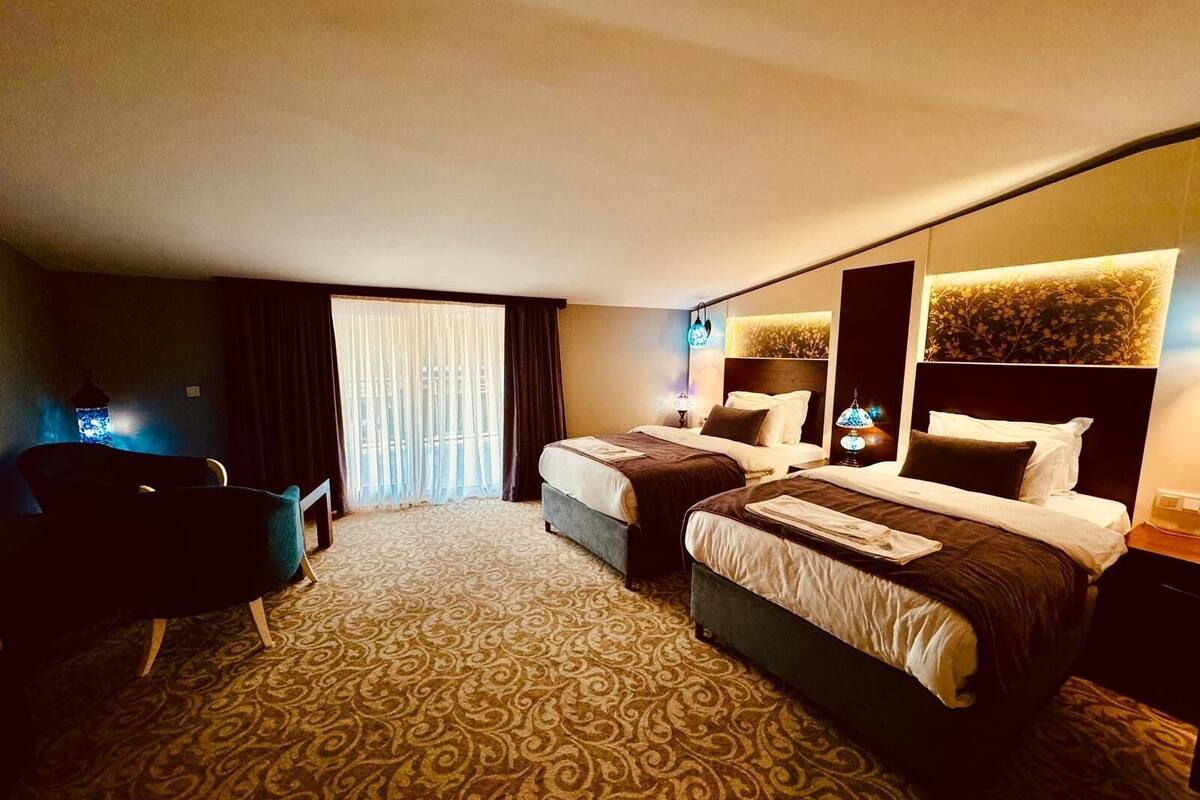 Ein Hotelzimmer mit zwei Betten, einem Schreibtisch und einem Stuhl.
