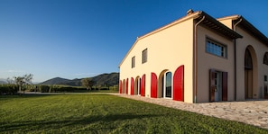 Un edificio con ingresso in pietra, prato curato e cielo sereno.