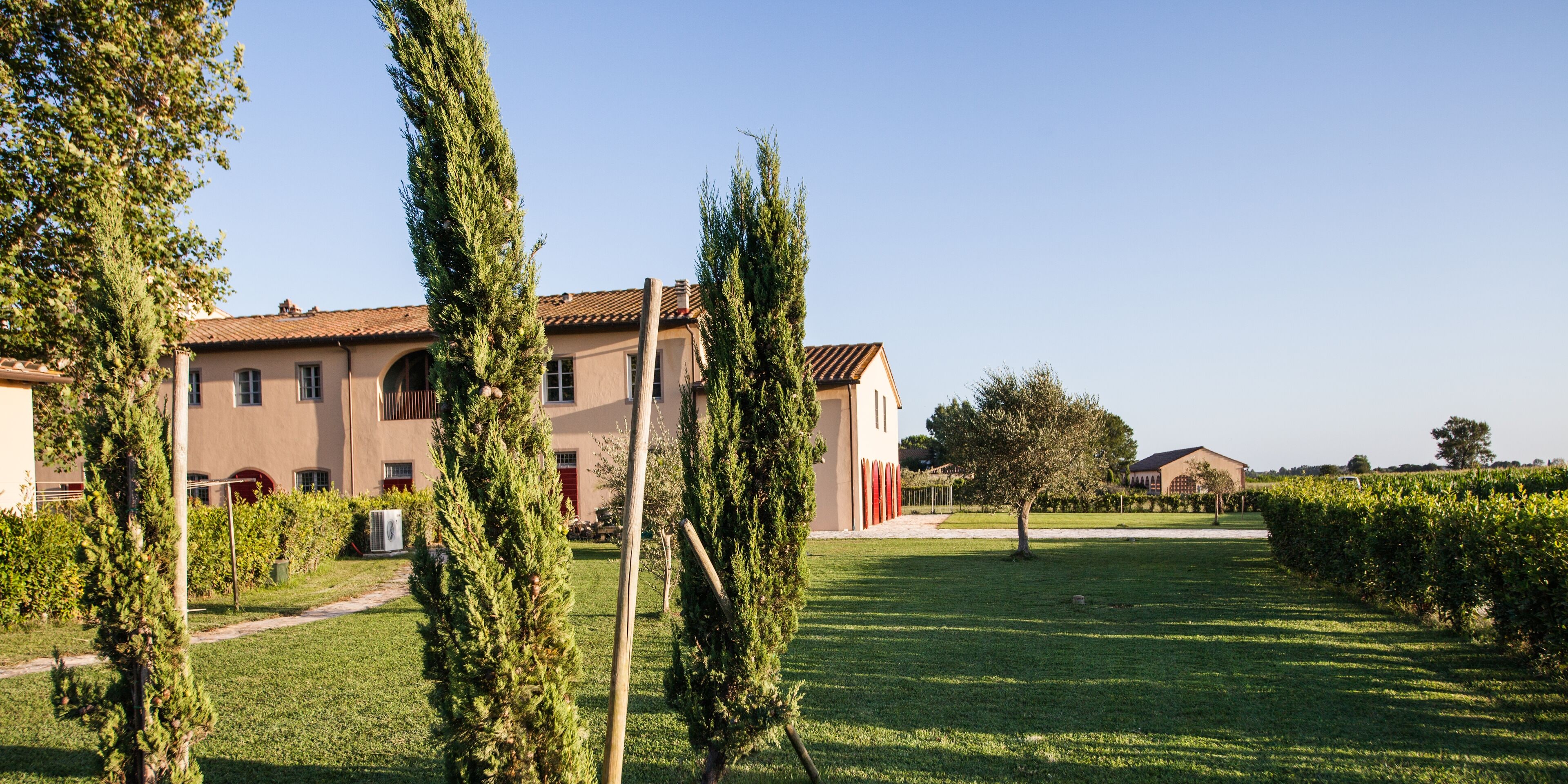 A large building with a tiled roof, surrounded by well-maintained grass and trees.