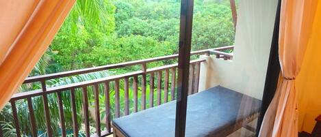 A balcony with a view of lush greenery.