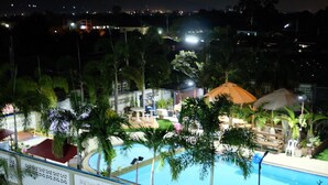 Ein Swimmingpool, umgeben von Palmen und einem Gazebo.