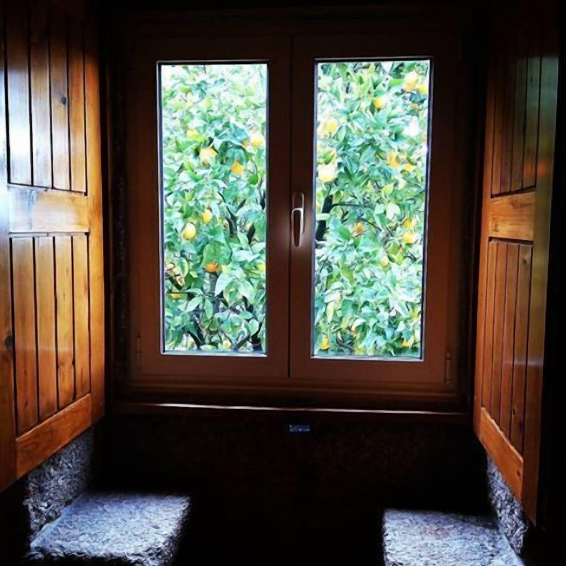 A wooden door with a window, leading to a stone staircase.
