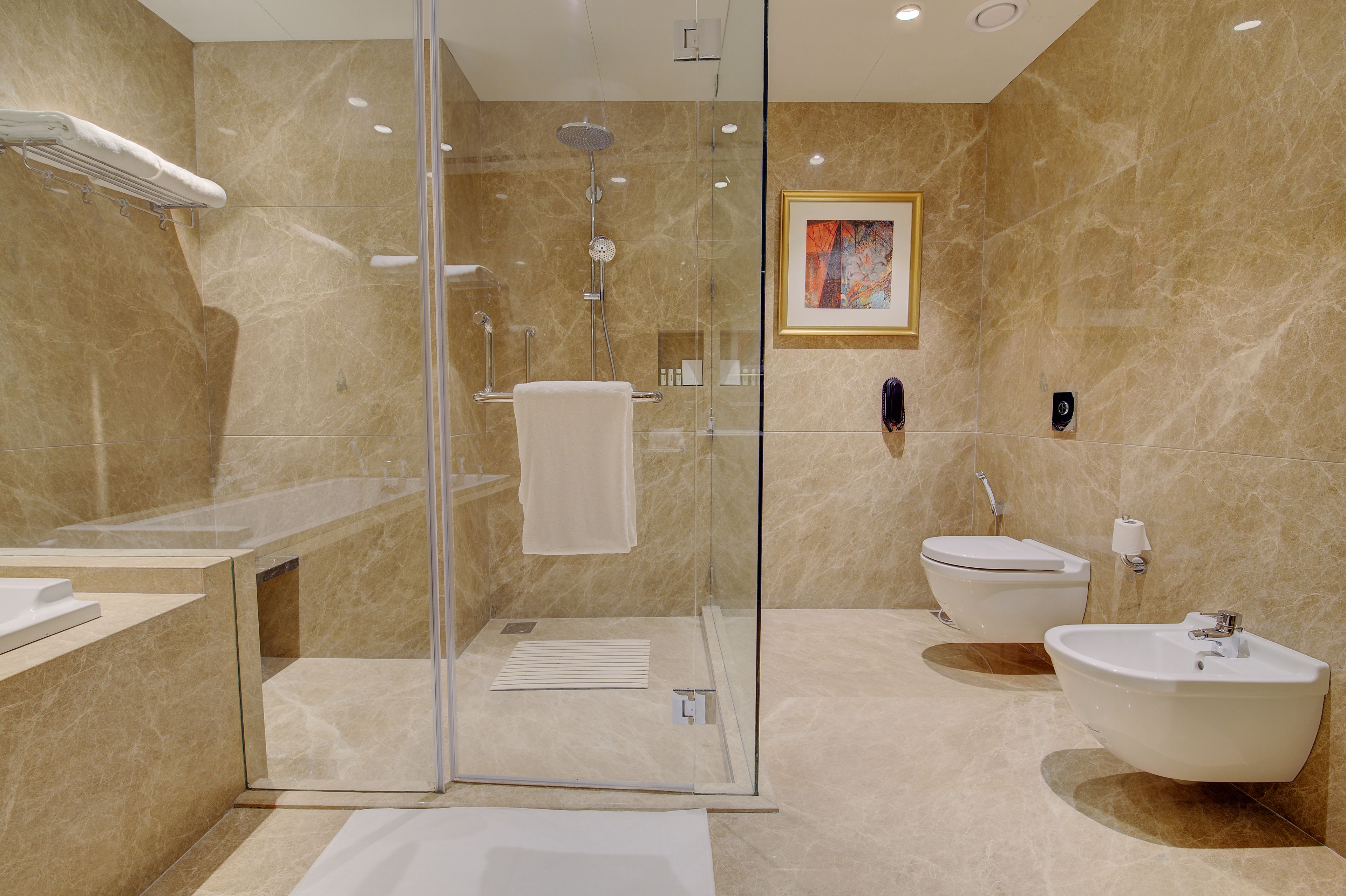 A modern bathroom with a glass-enclosed shower, a freestanding bathtub, and a toilet.