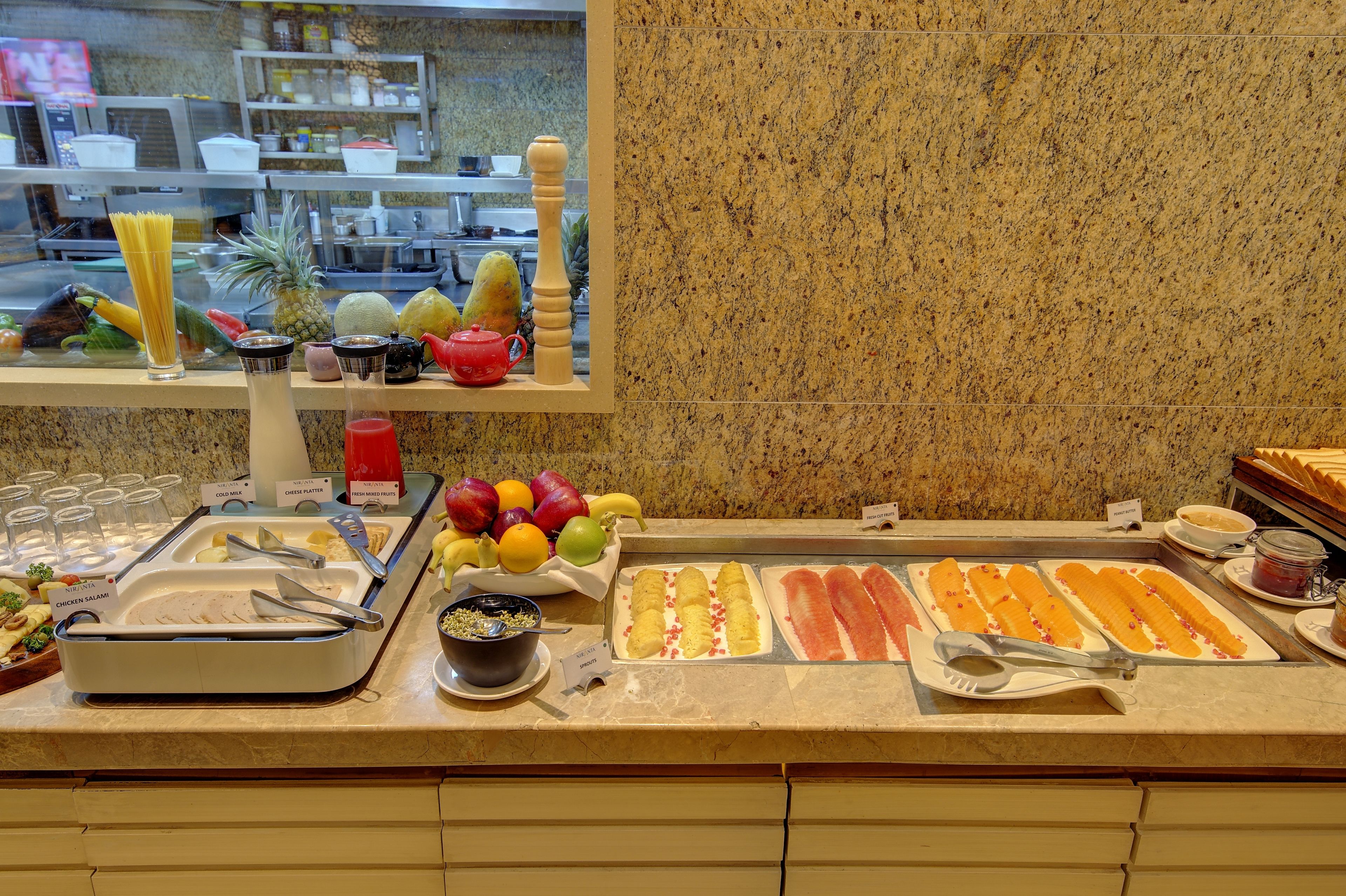 Een buffet met diverse gerechten, waaronder pasta, fruit en salades.