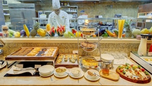 A buffet with various food items and a chef preparing food. - Niranta Airport Transit Hotel & Lounge Terminal 2 Arrivals (Mumbai)