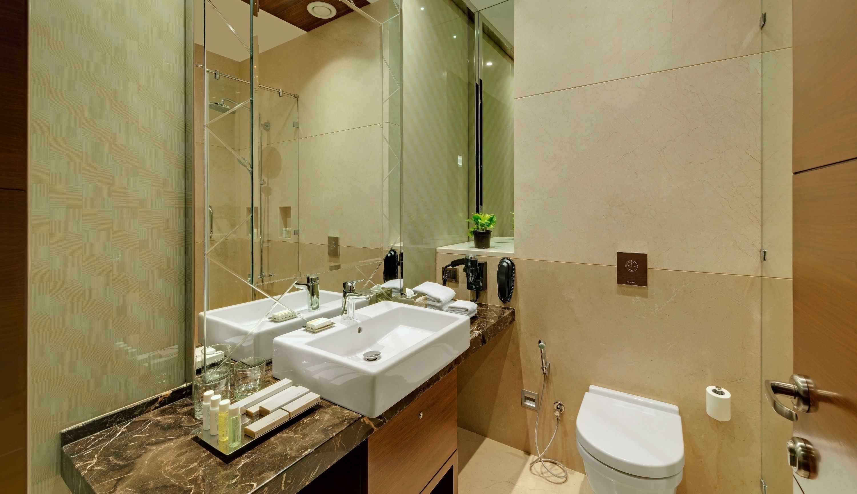 Un baño moderno con dos lavabos, ducha y retrete.