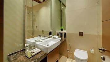 Un baño moderno con dos lavabos, ducha y retrete.