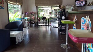 Una habitación con sofá, una silla, una mesa y una encimera con televisor.