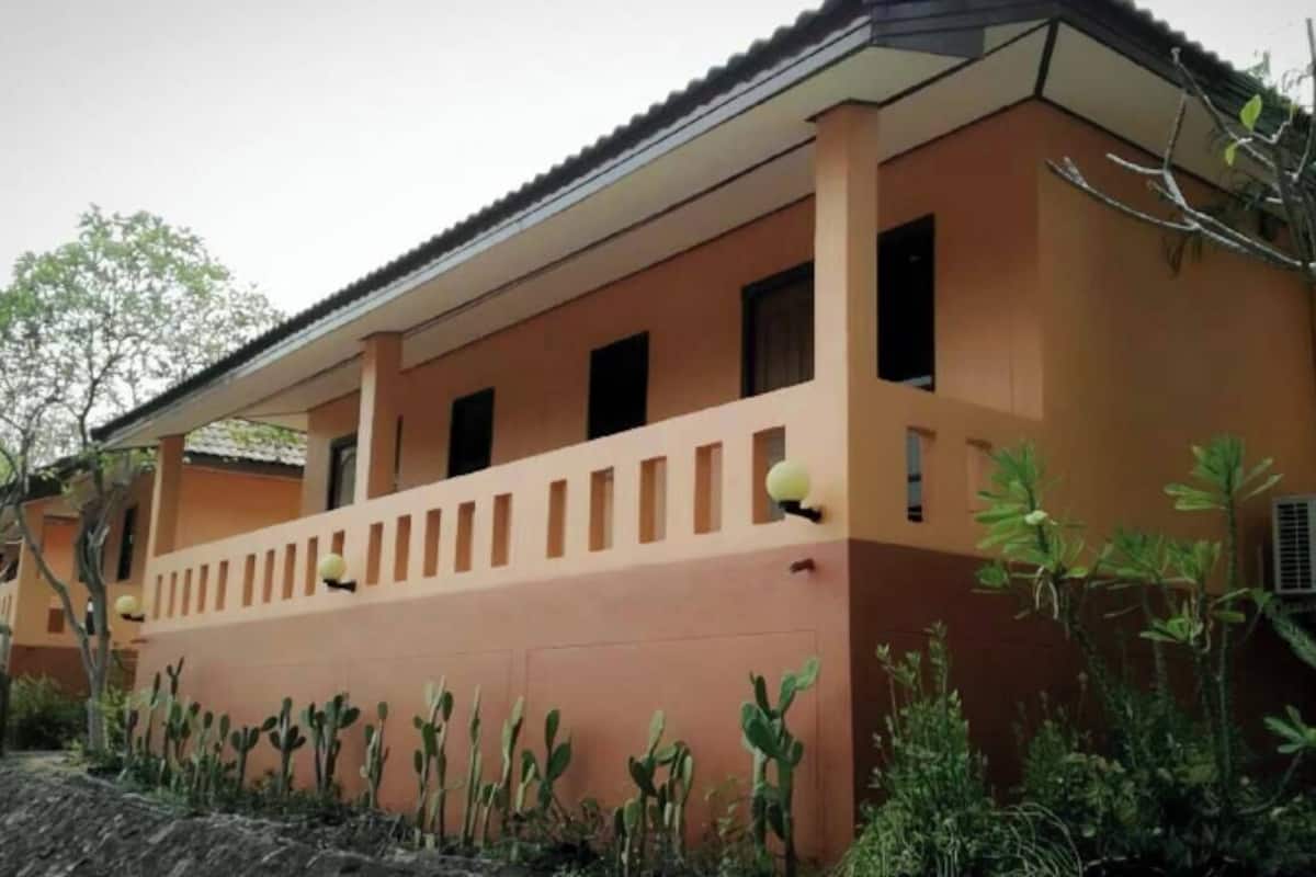 A building with a flat roof, multiple windows, and a small balcony with a railing.